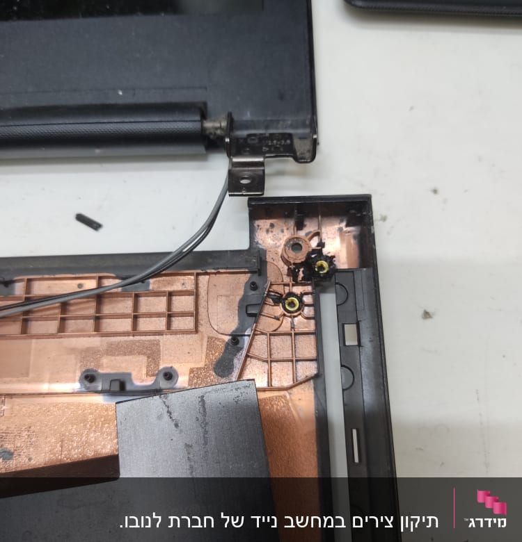 חלקי מחשב נייד פתוחים עם צירים וחוטים גלויים